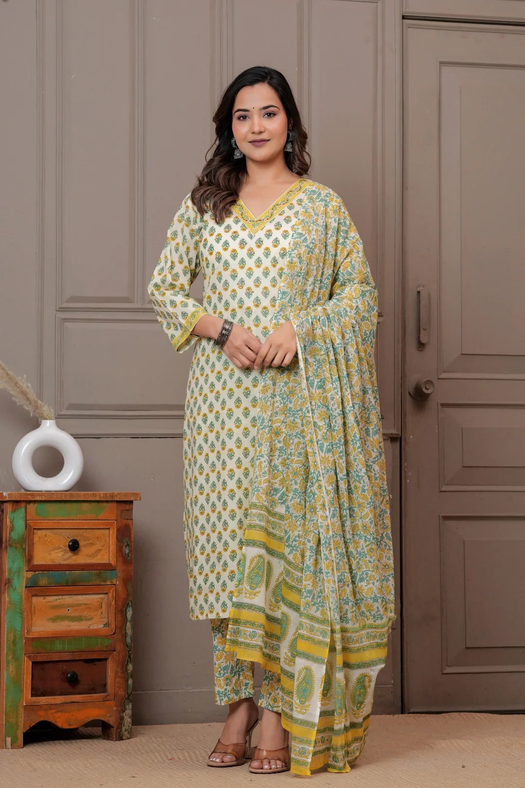 Woman wearing an off-white cotton kurta set with yellow and green Jaipur handblock floral prints and a matching paisley dupatta.